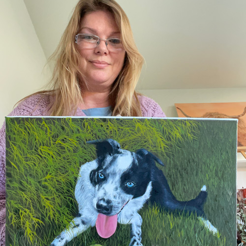 Claire Dale, Sussex artist, holding completed painting